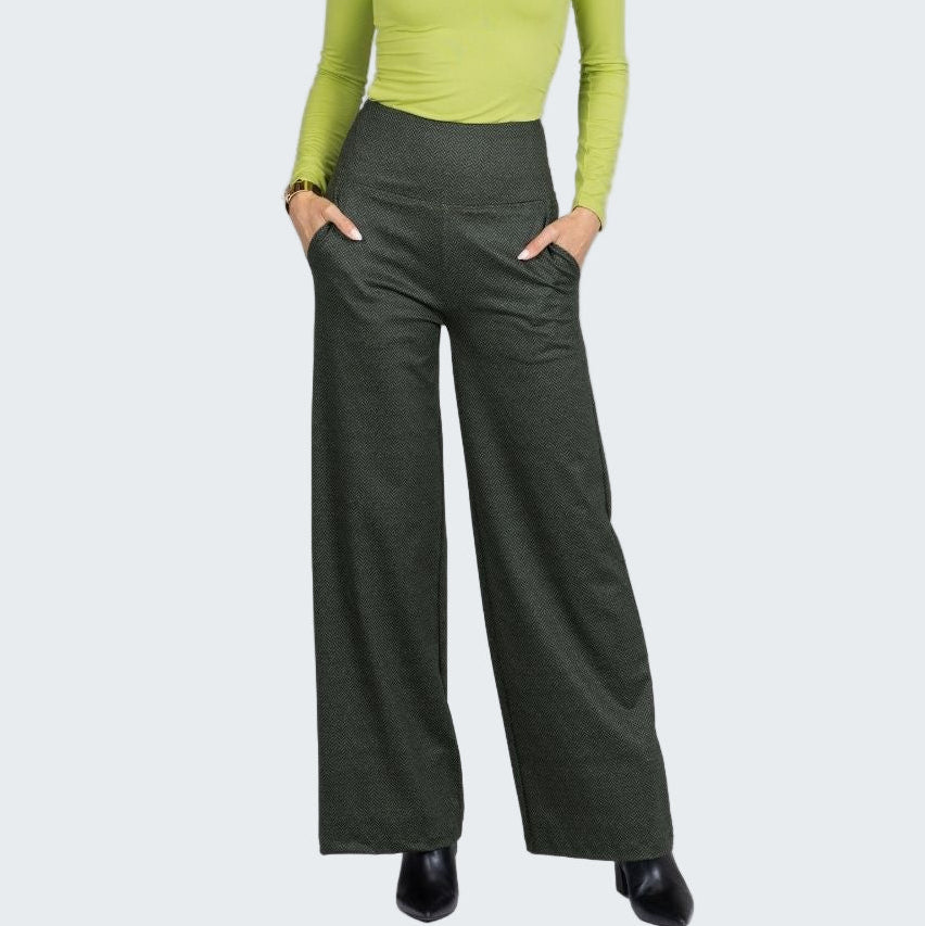 Woman wearing a green top and dark green wide-leg pants on a white background