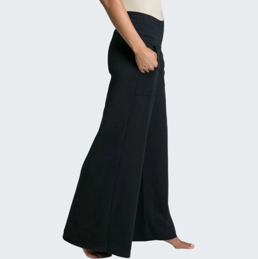 Person wearing black wide-leg pants on a plain background