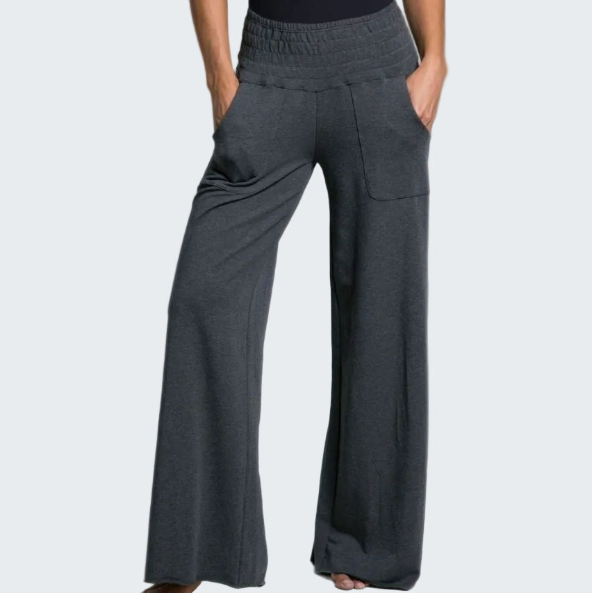Person wearing dark gray wide-leg pants on a plain background