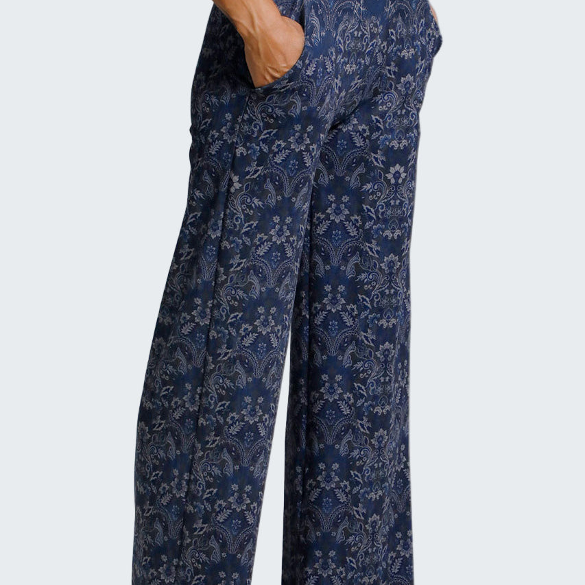 Navy floral-patterned pants worn by a person on a light gray background