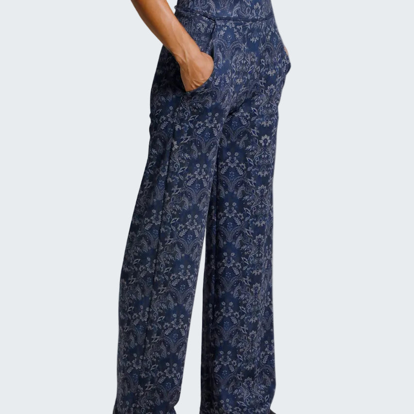 Navy floral-patterned pants worn by a person on a light gray background
