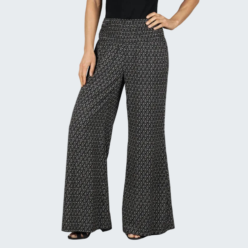 Black patterned pants worn by a person on a gray background