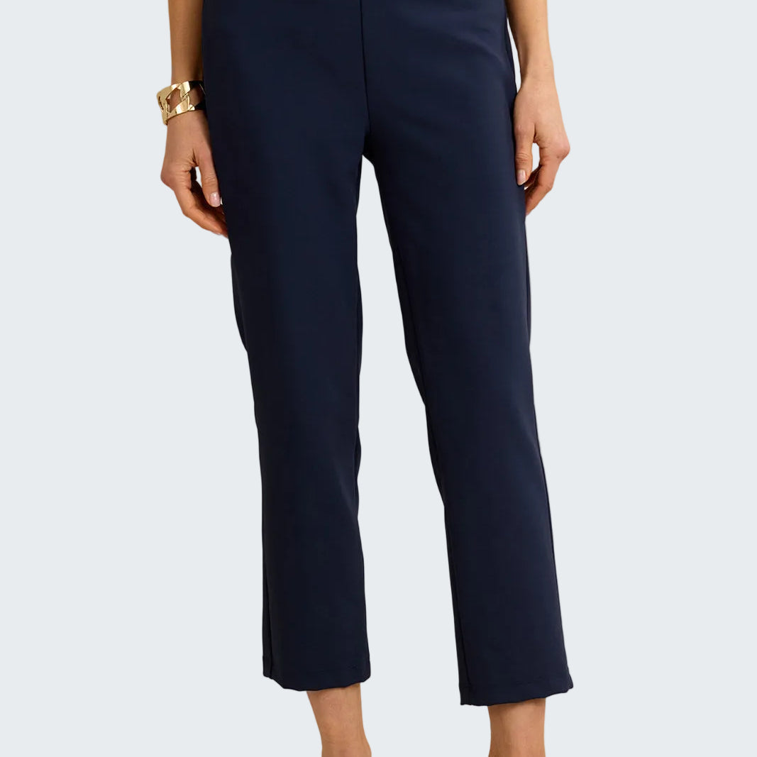 Navy blue pants worn by a person on a beige background