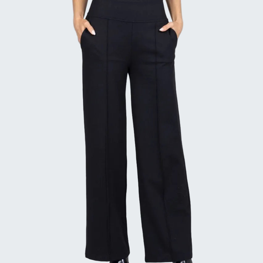 Person wearing black high-waisted pants on a white background