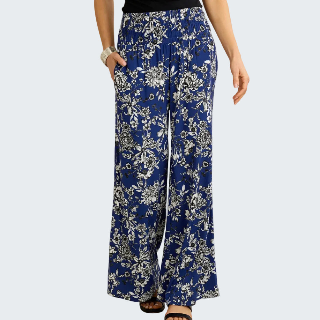 Blue floral-patterned pants worn by a person on a beige background