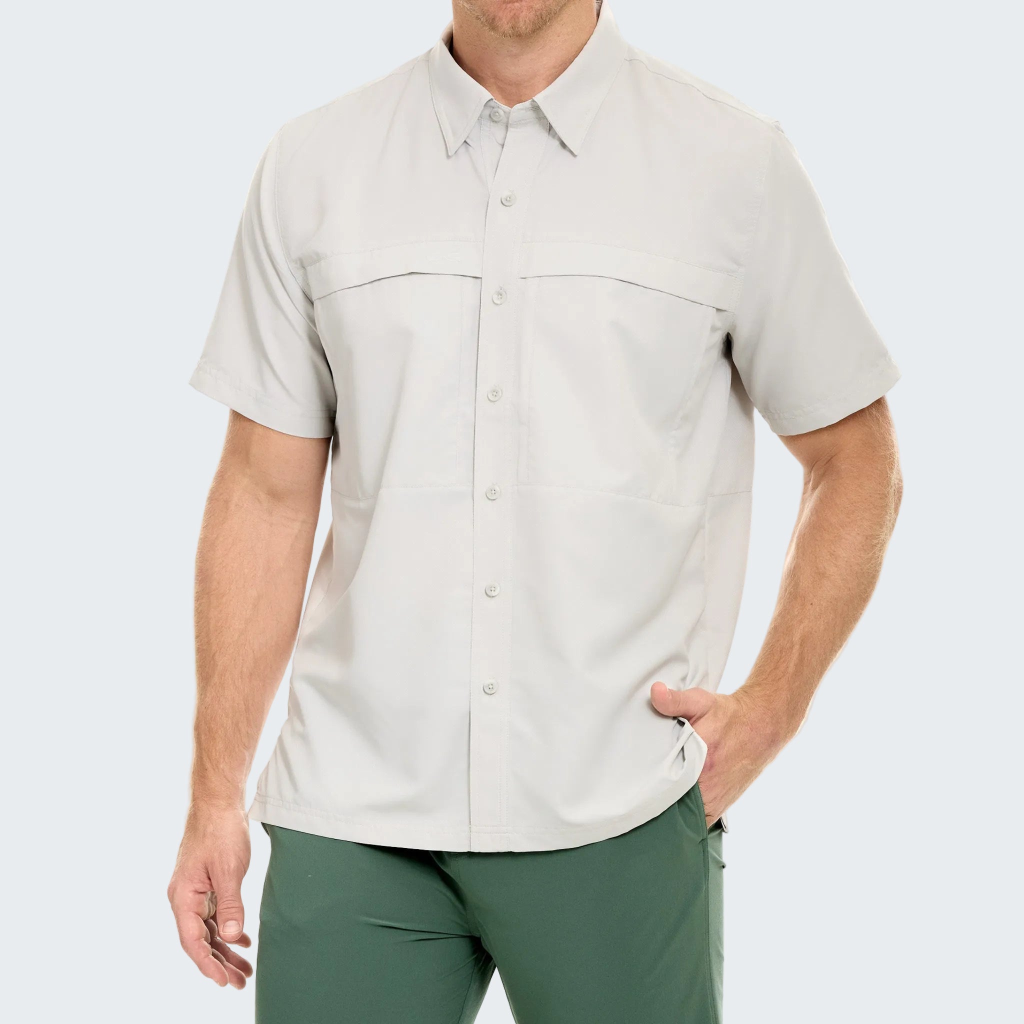 Man wearing a light gray short-sleeve shirt and green pants on a white background