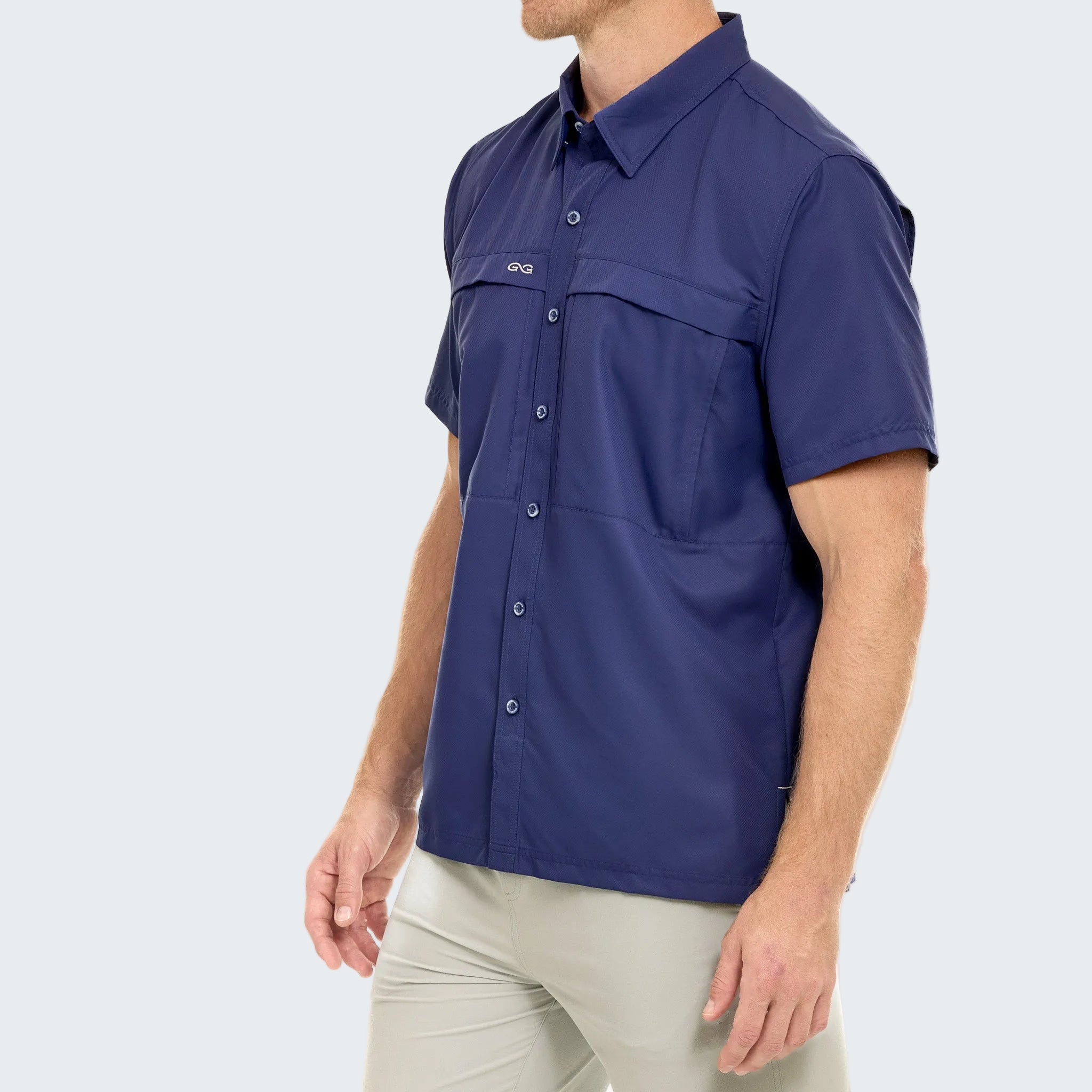 Man wearing a blue sleeveless shirt with a brand logo on a white background