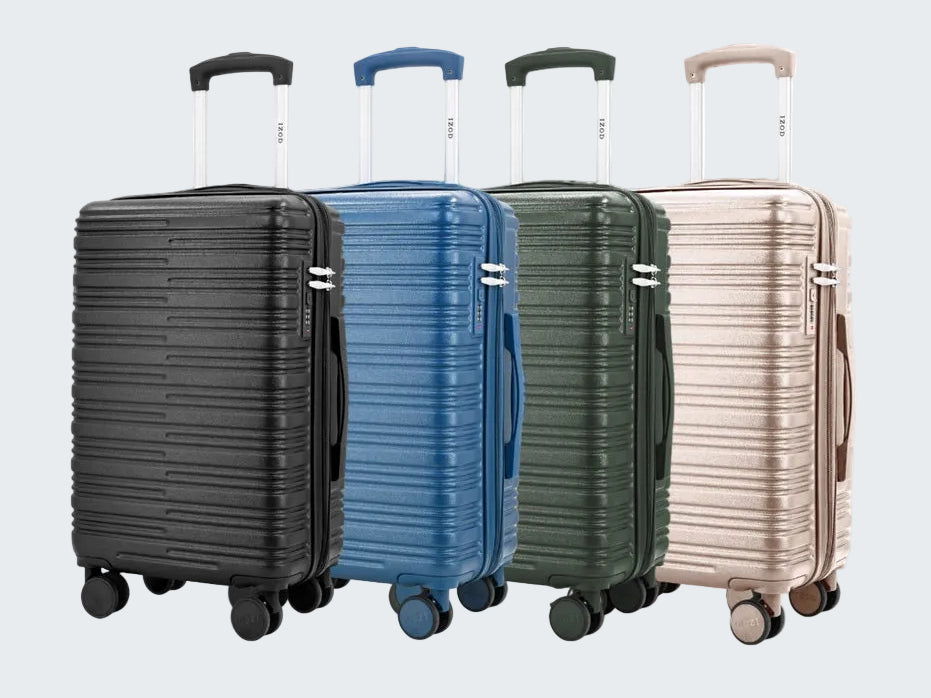 Four suitcases in black, blue, green, and beige on a white background