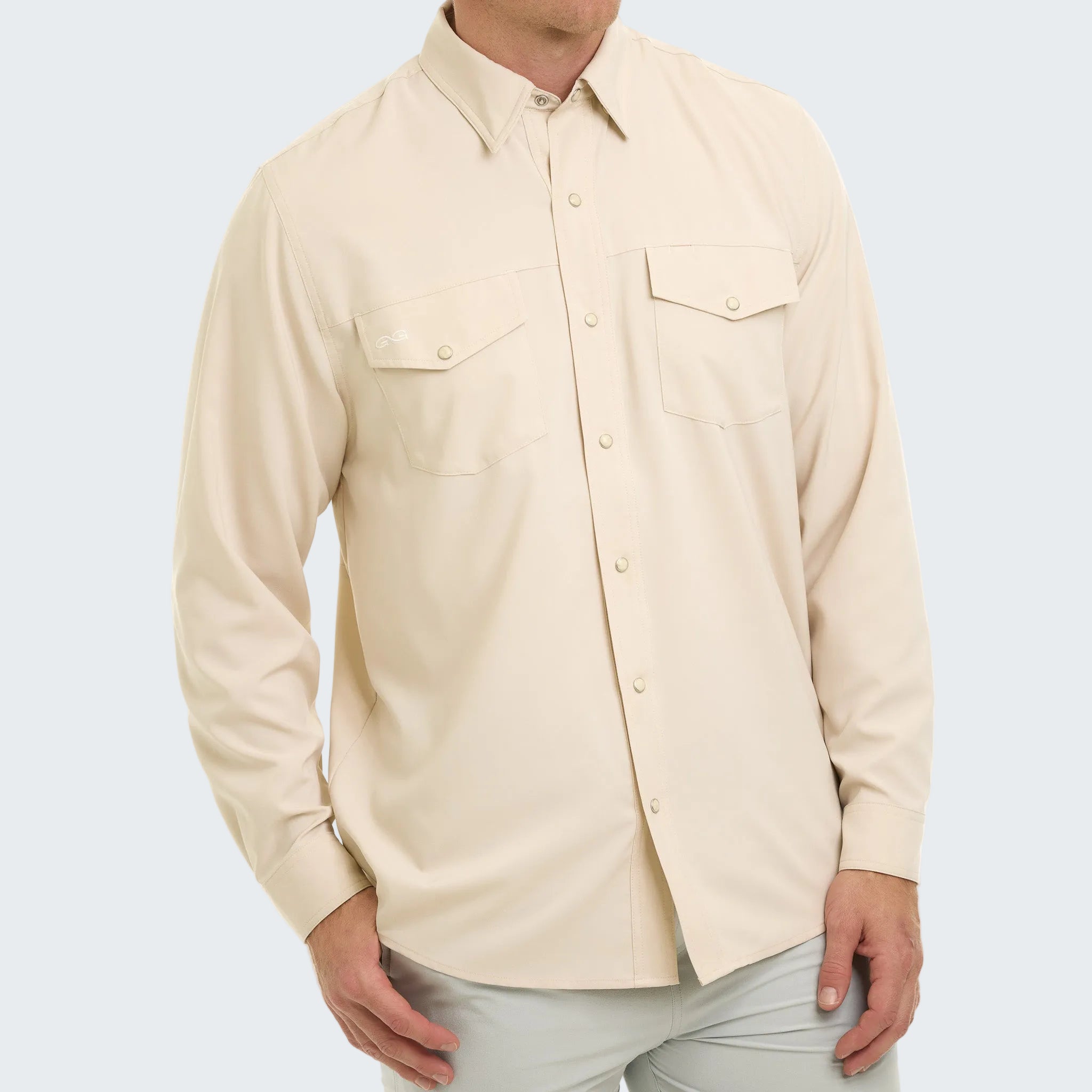 Beige button-up shirt worn by a person on a white background