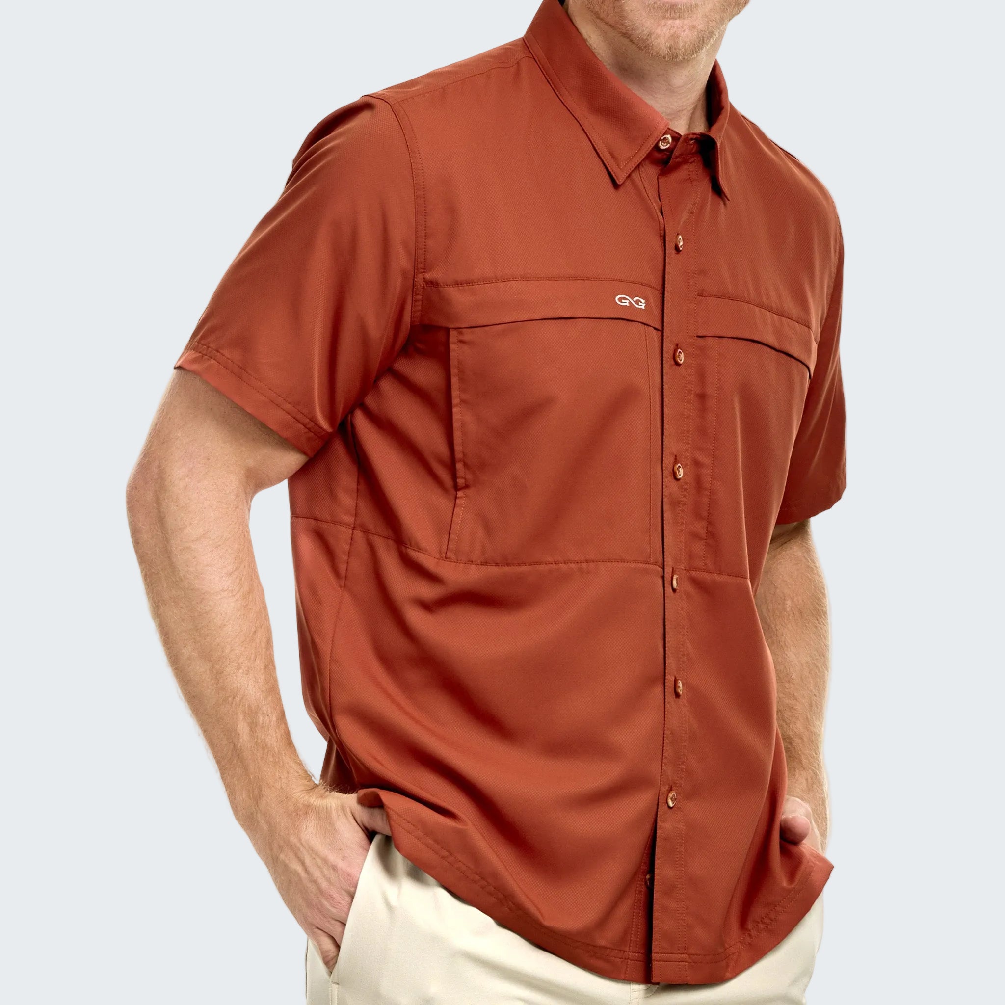 Man wearing a rust-colored short-sleeve shirt on a white background