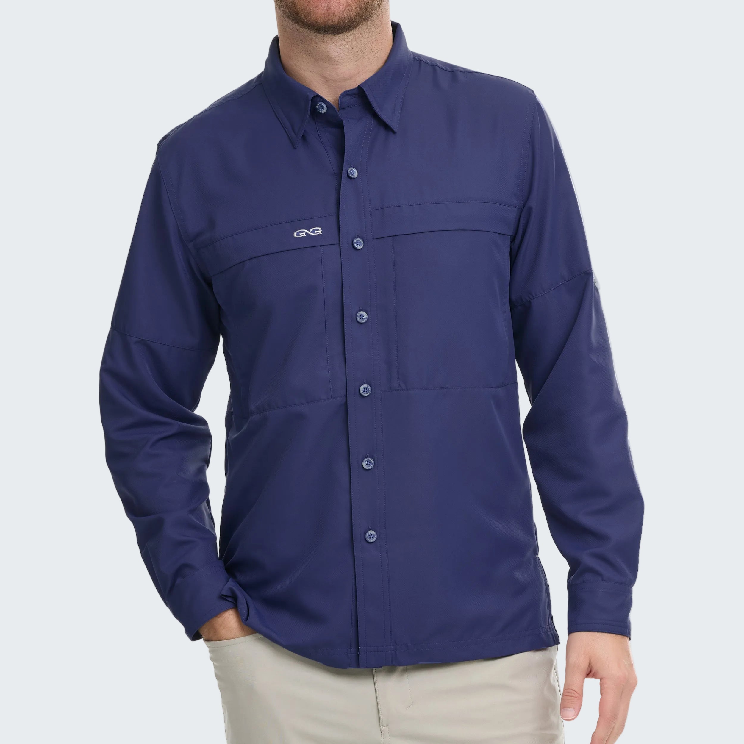 Man wearing a blue button-up shirt with a logo on a white background