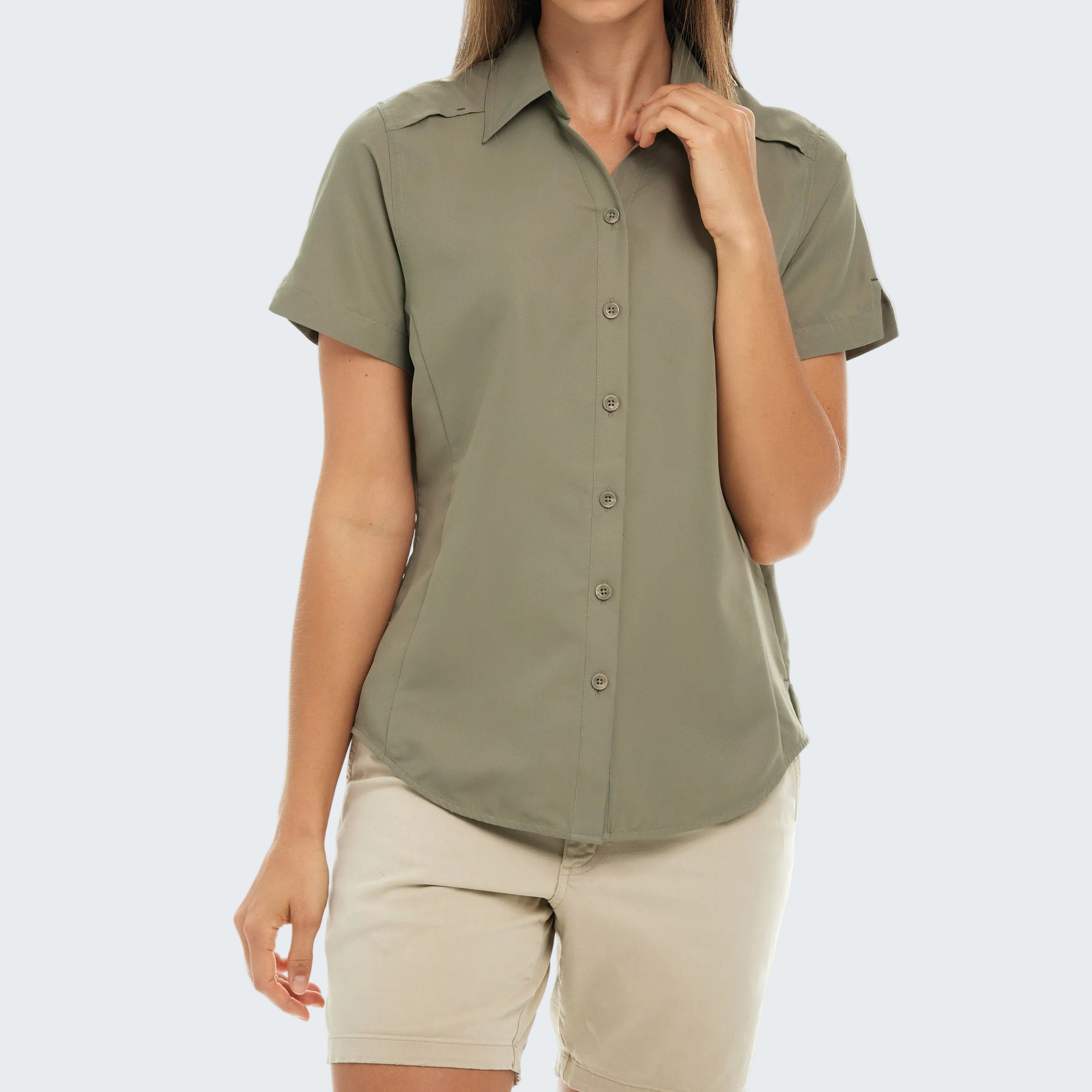 Person wearing a green button-up shirt and beige shorts on a white background
