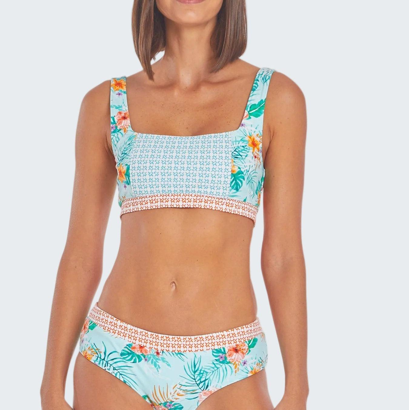 Woman wearing a tropical patterned bikini set on a white background