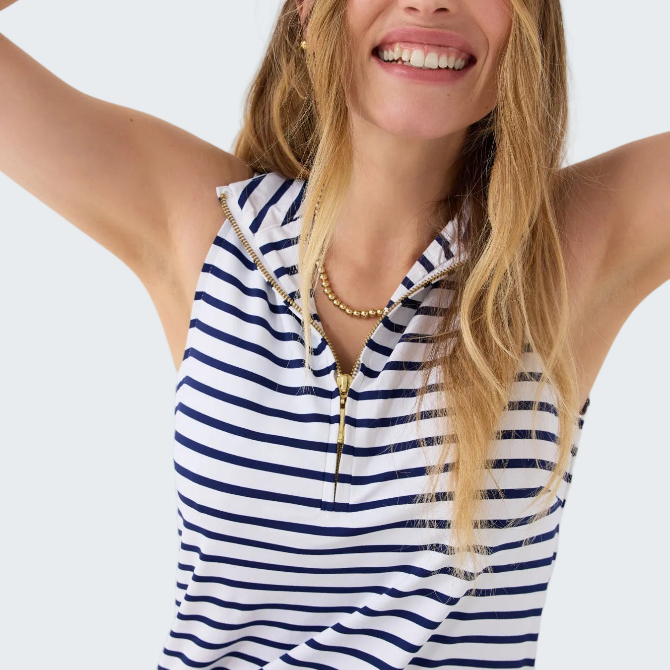 Woman wearing a blue and white striped sleeveless top on a white background