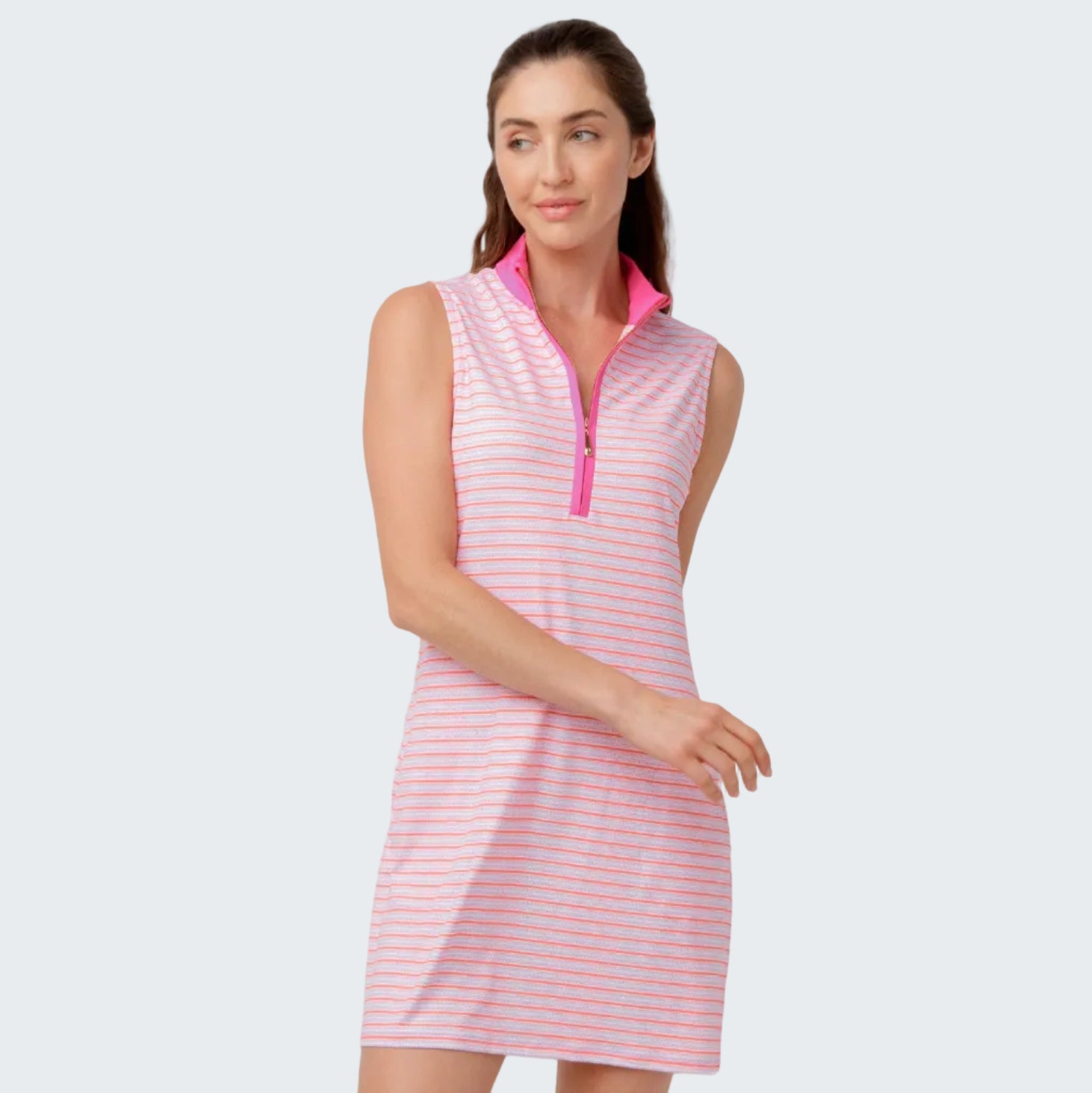 Woman wearing a pink and white striped dress with a high collar on a light gray background