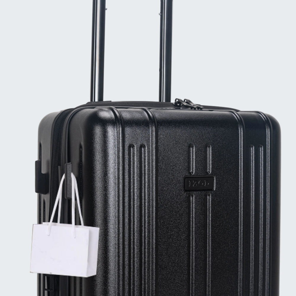 Black suitcase with a white shopping bag attached on a light gray background