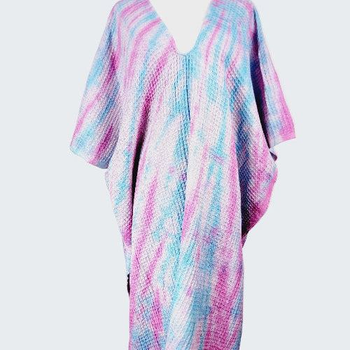 Colorful poncho with pink and blue patterns on a white background