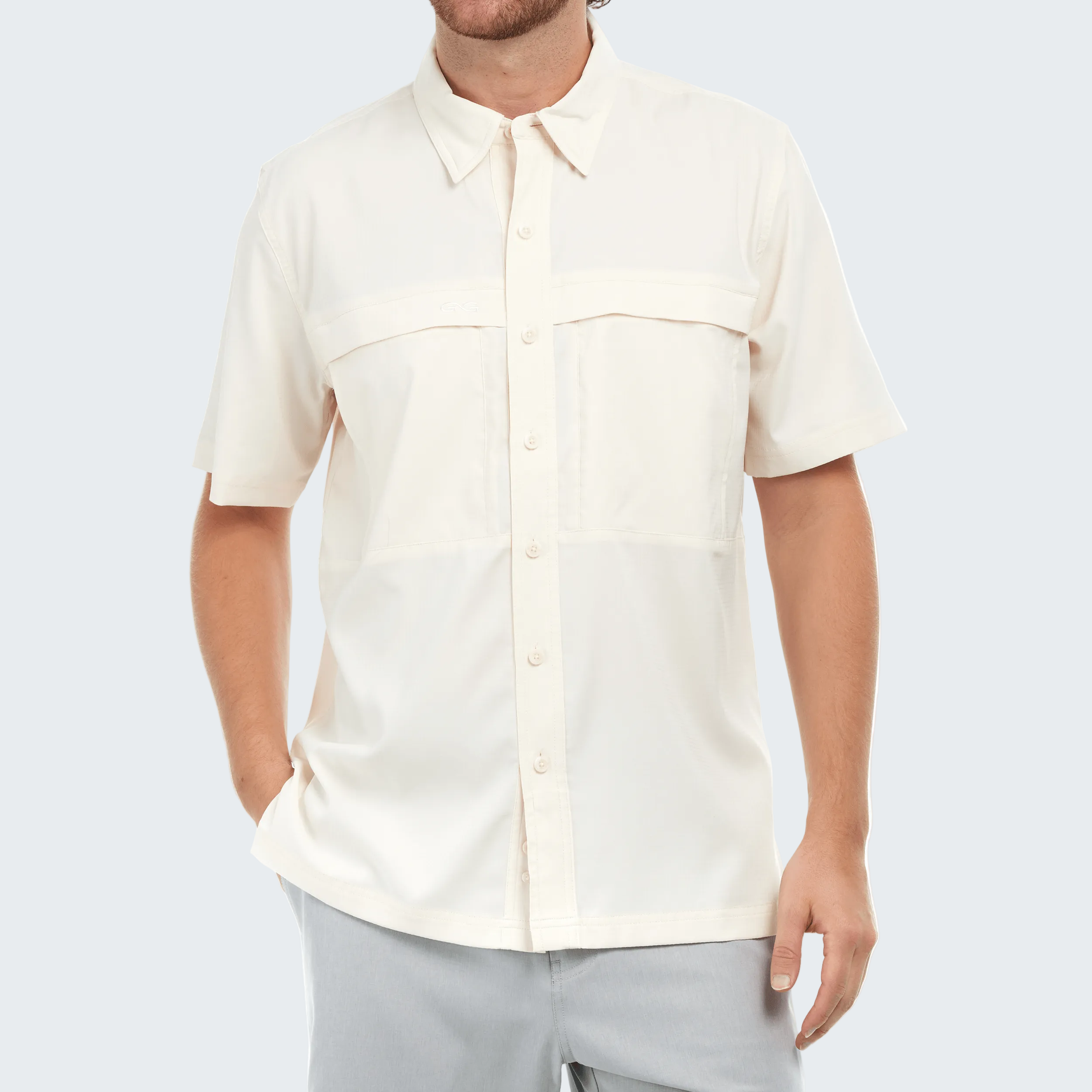 Man wearing a cream short-sleeve shirt on a white background