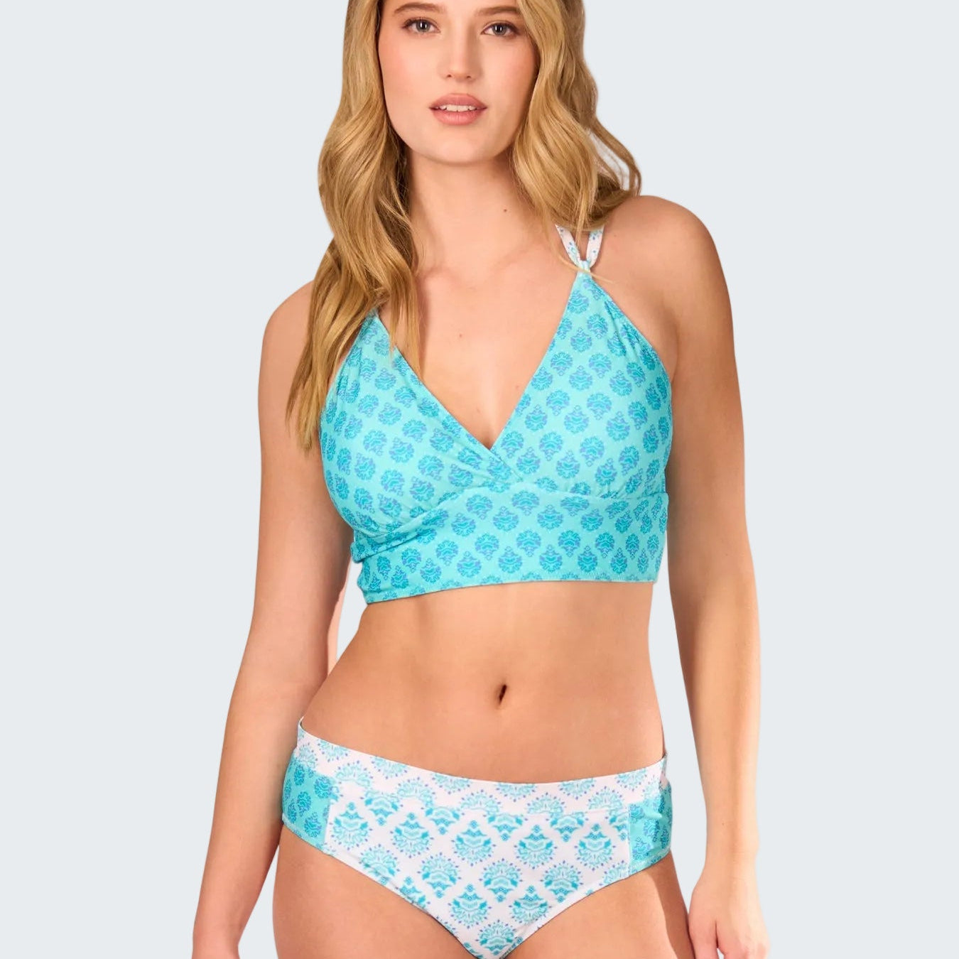 Woman wearing a blue and white patterned bikini set on a white background