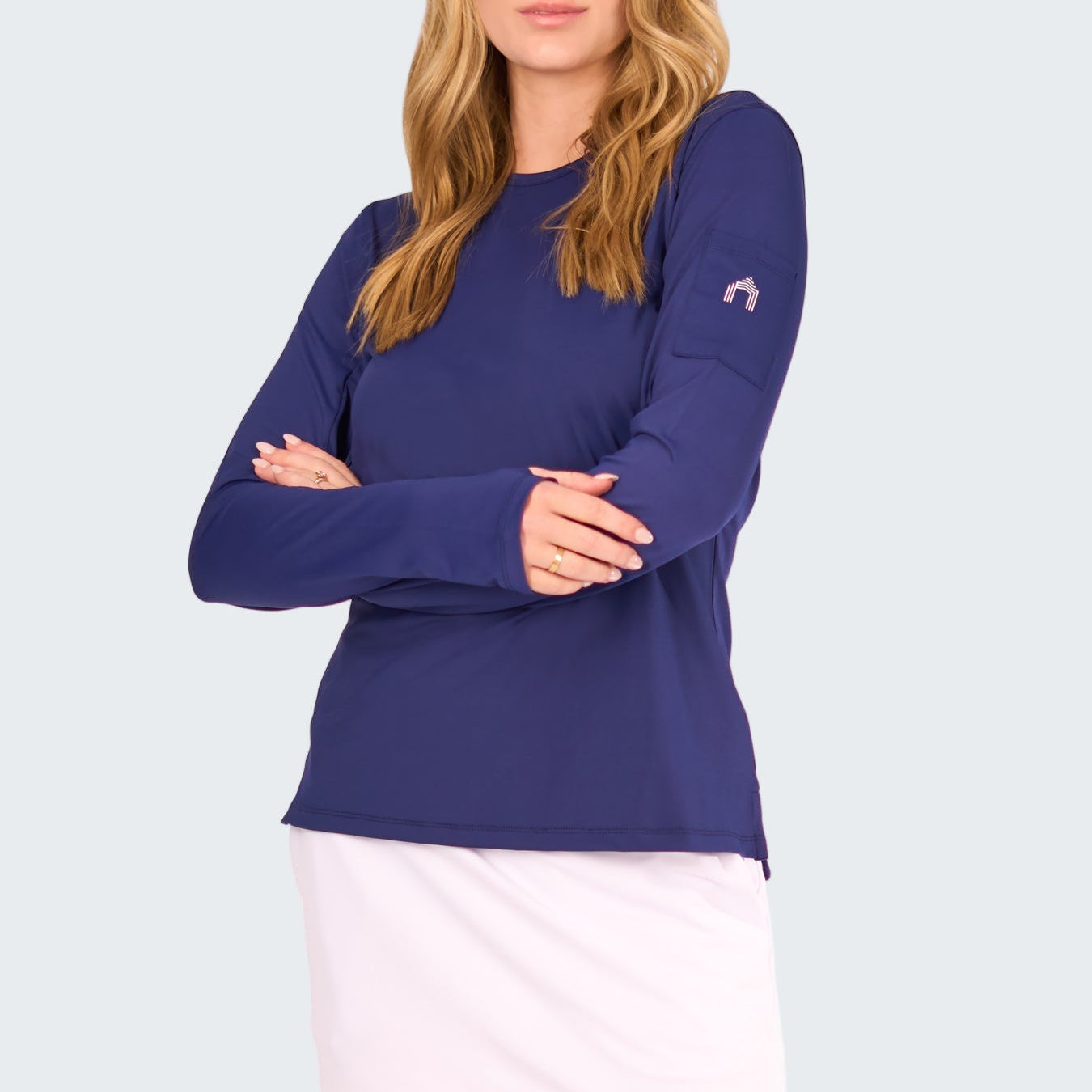 Woman wearing a blue long-sleeve top and white skirt on a white background