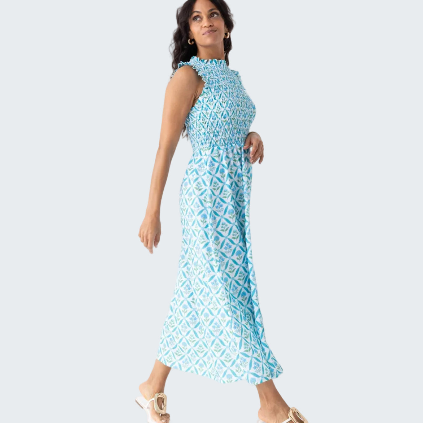 Woman wearing a blue patterned dress against a white background