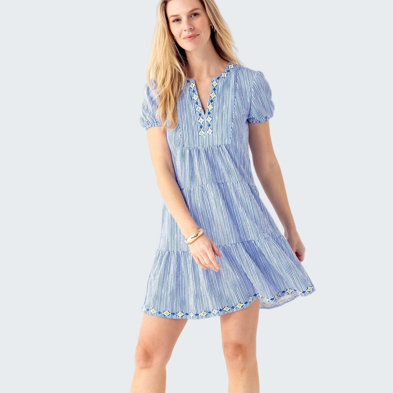 Woman wearing a blue and white striped dress on a white background