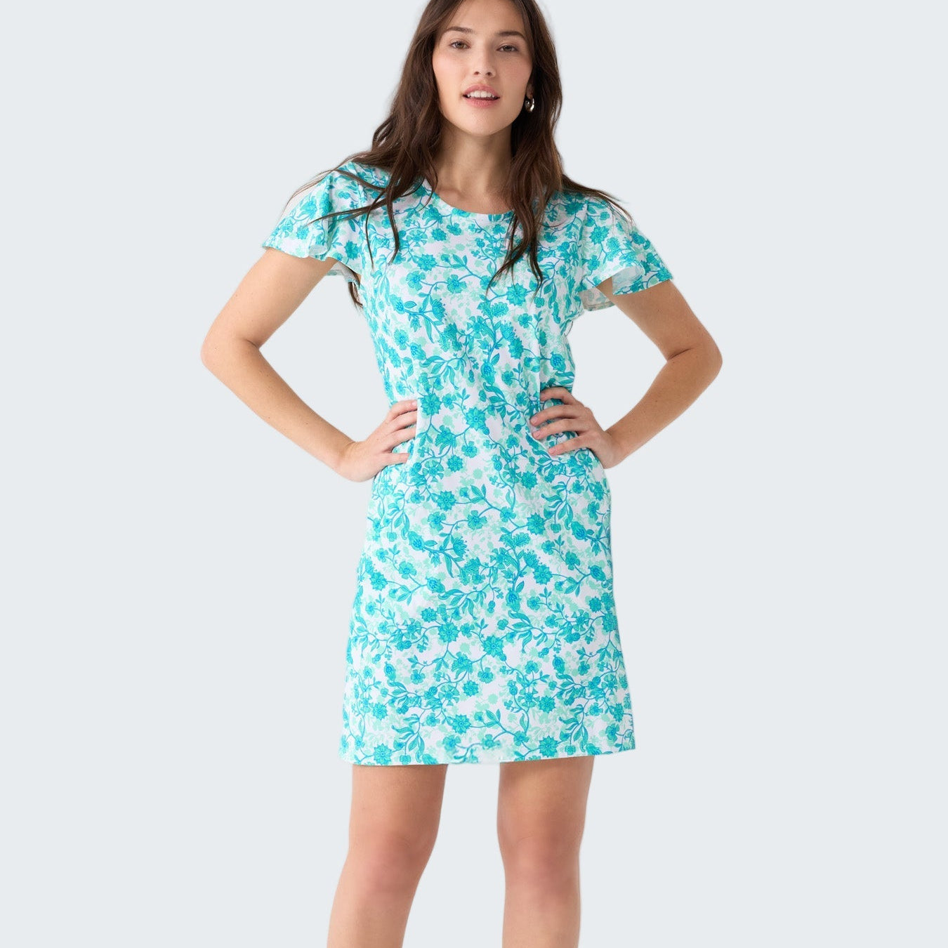 Woman wearing a turquoise floral dress on a white background