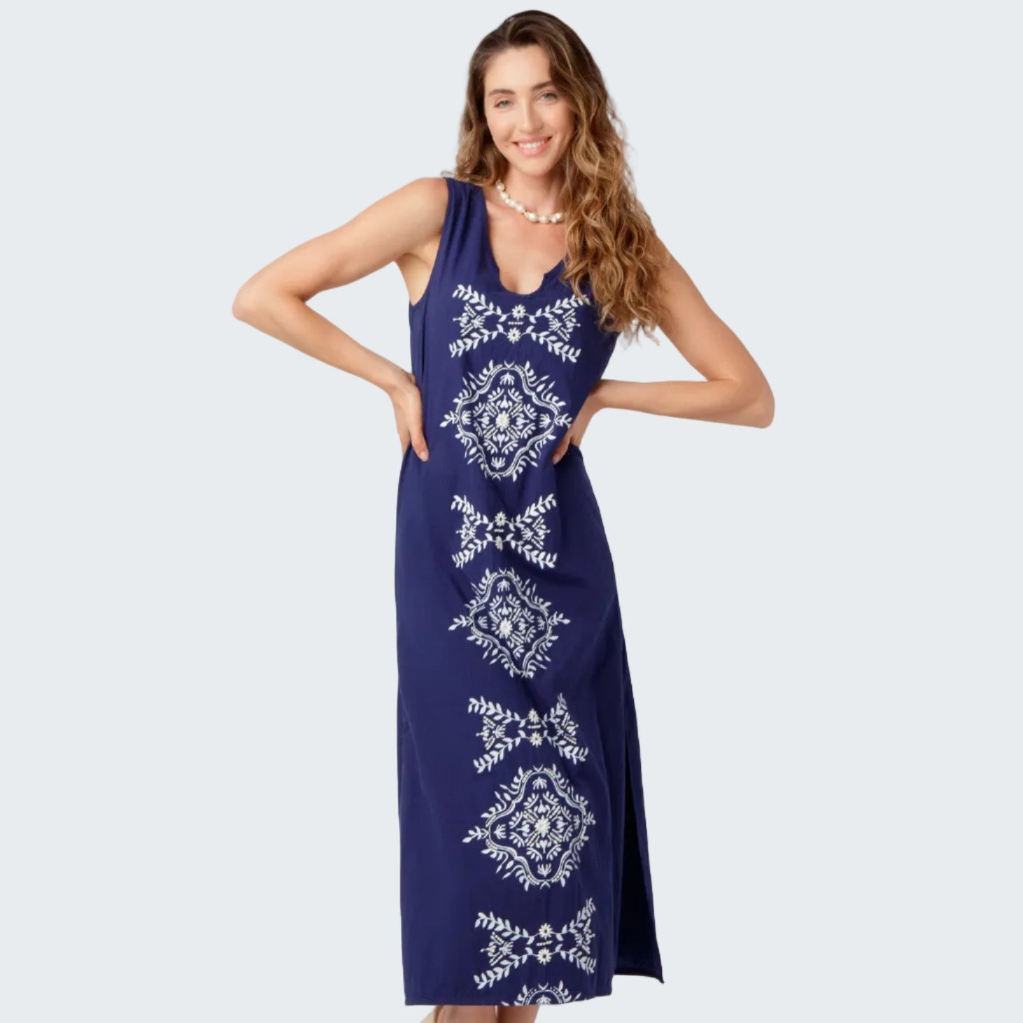 Woman wearing a blue dress with white patterns on a white background