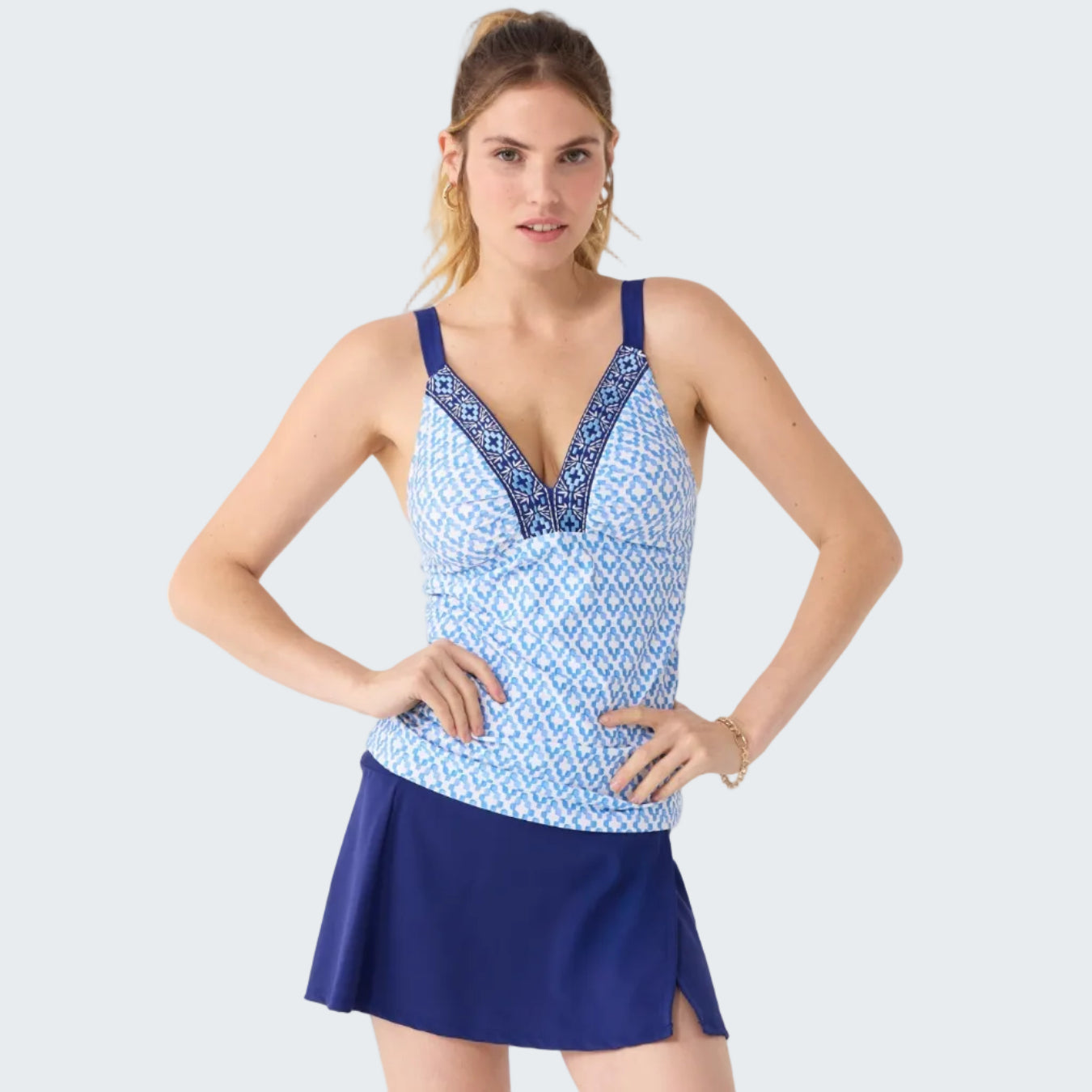 Woman wearing a blue and white patterned tank top with a matching skirt on a white background