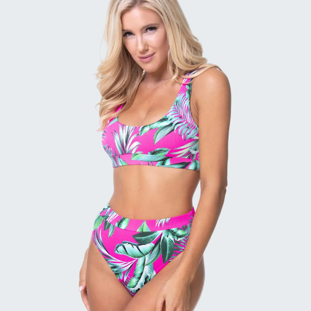 Woman wearing a tropical leaf patterned bikini set on a white background
