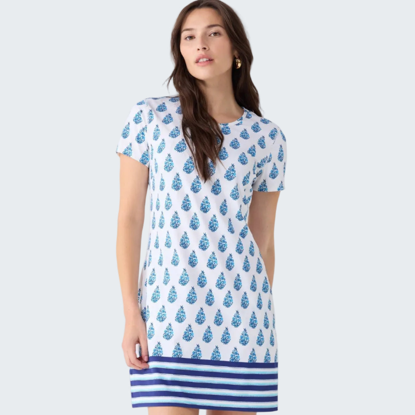 Woman wearing a blue and white patterned dress on a light gray background