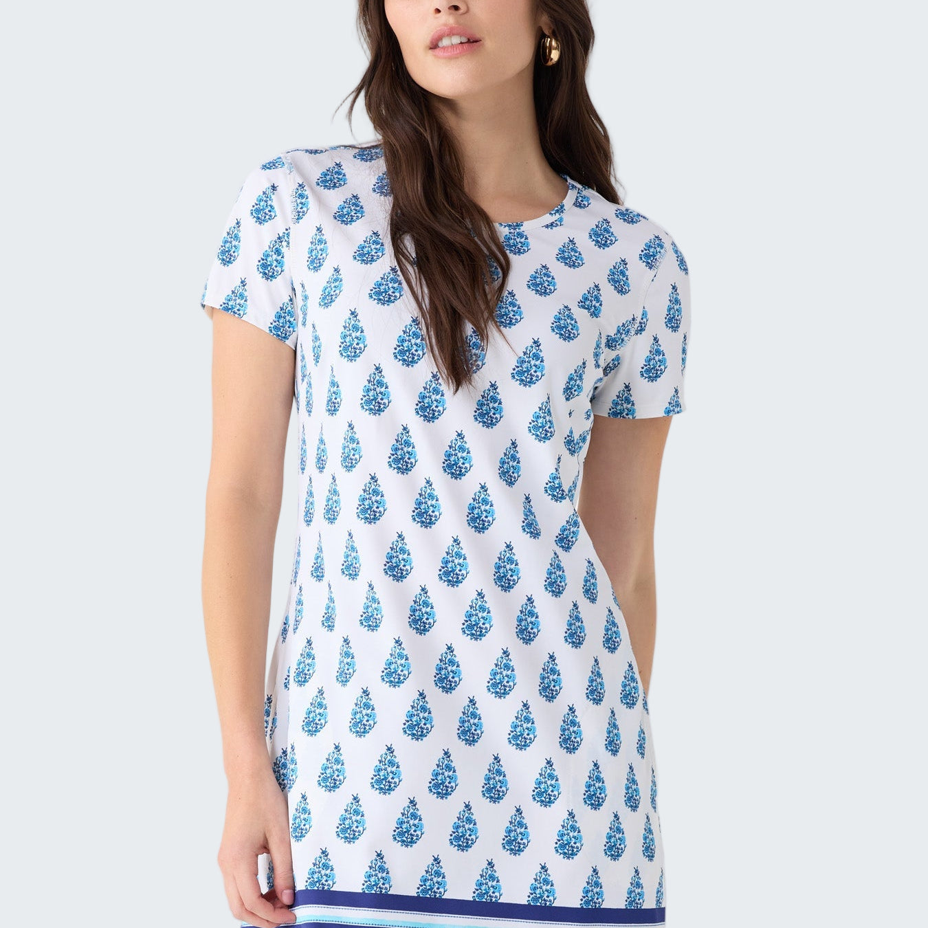Woman wearing a blue and white patterned dress on a light gray background