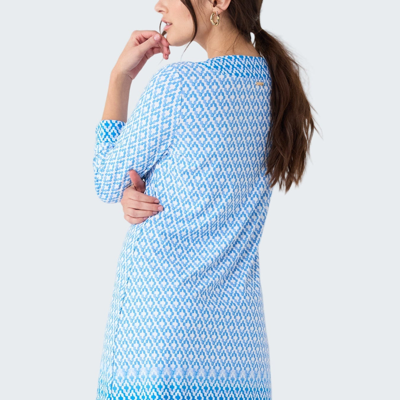 Woman wearing a blue patterned dress on a white background