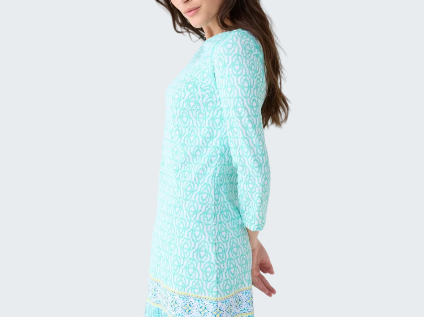 Woman wearing a light blue dress with a pattern on a white background