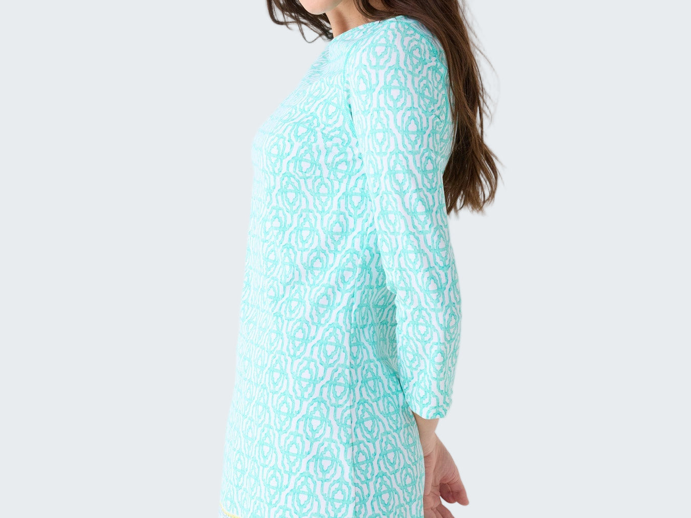 Woman wearing a light blue dress with a pattern on a white background