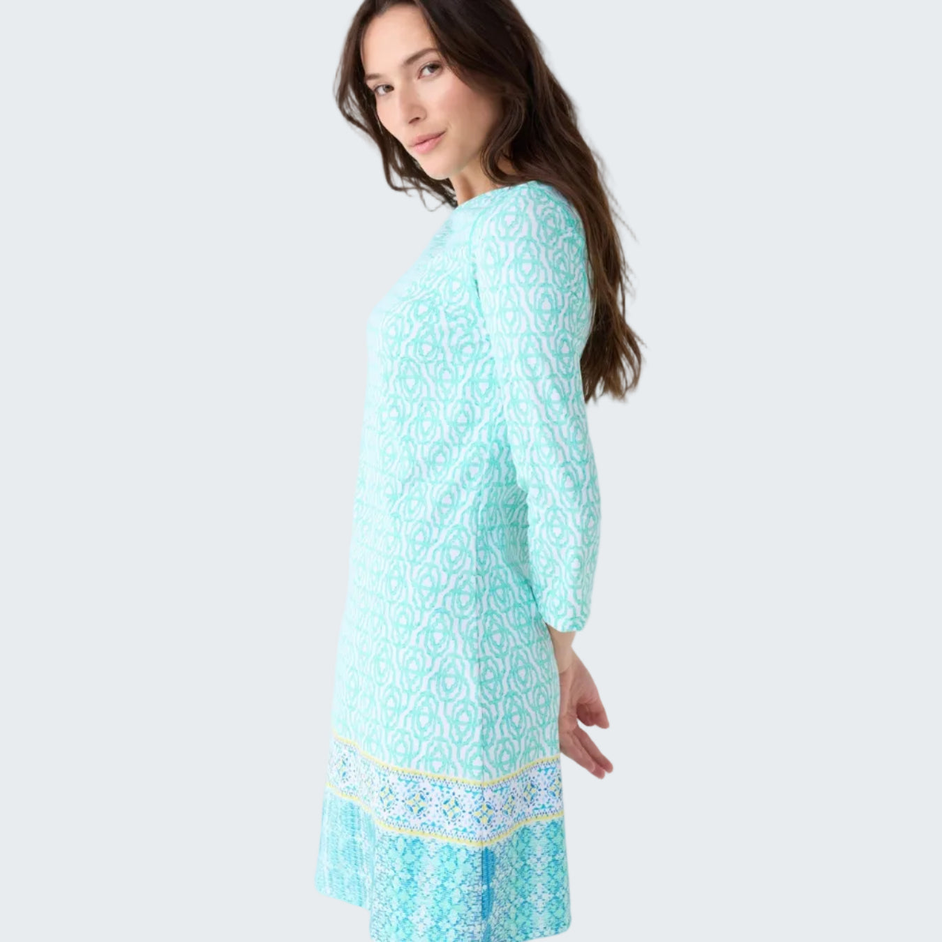 Woman wearing a light blue dress with a pattern on a white background