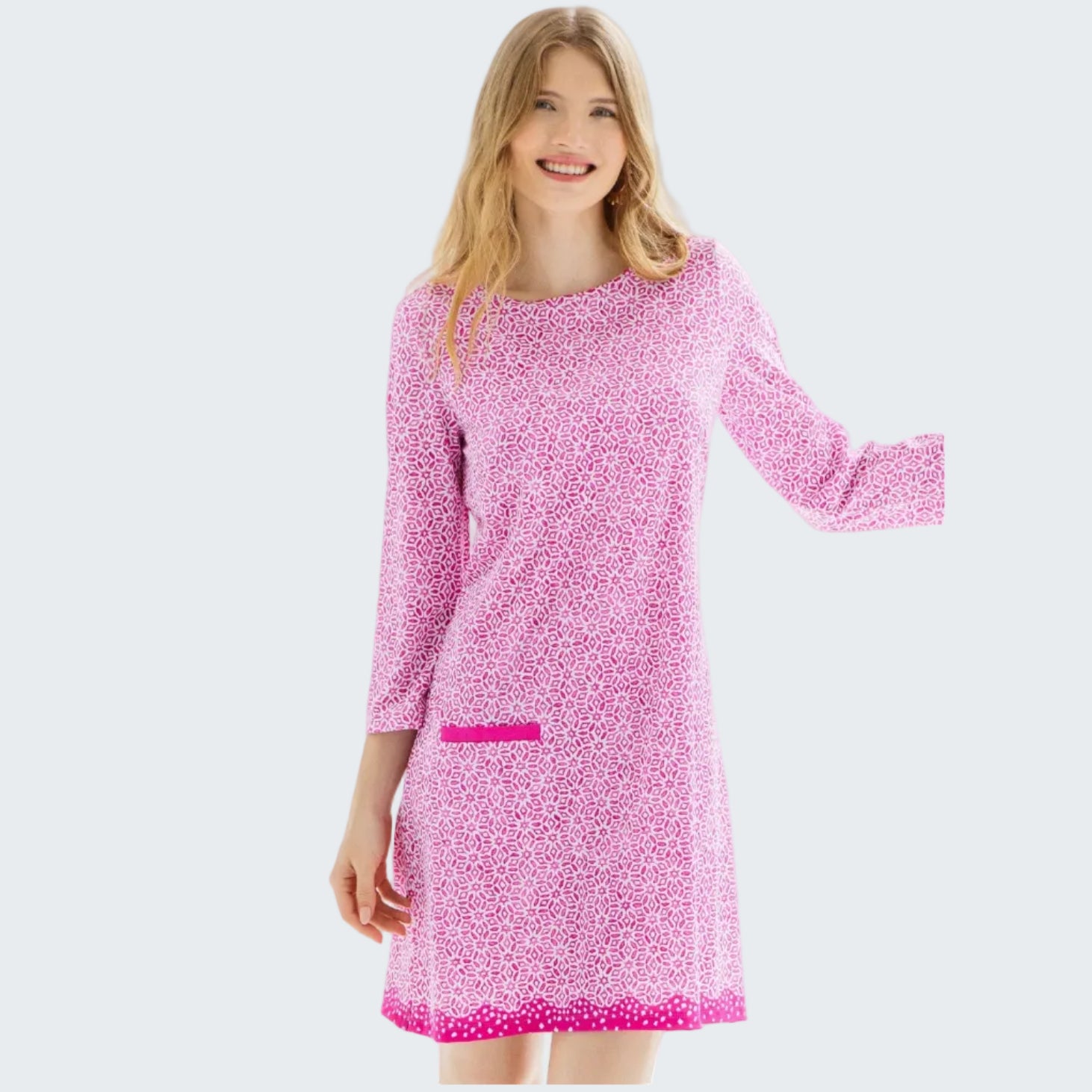 Woman wearing a pink patterned dress against a white background