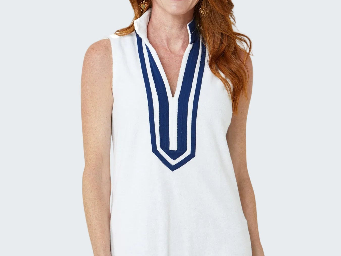 Woman wearing a white dress with blue trim on a white background