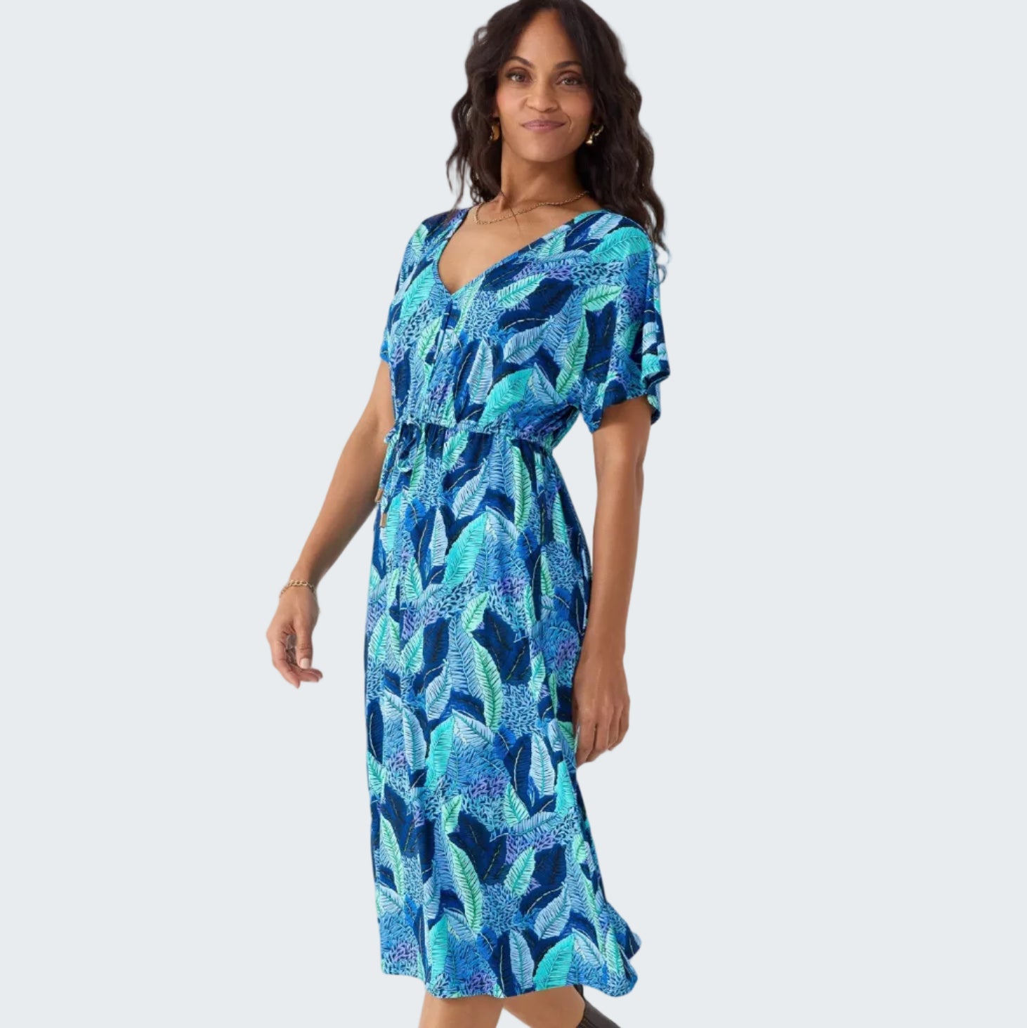 Woman wearing a blue and green patterned dress on a white background