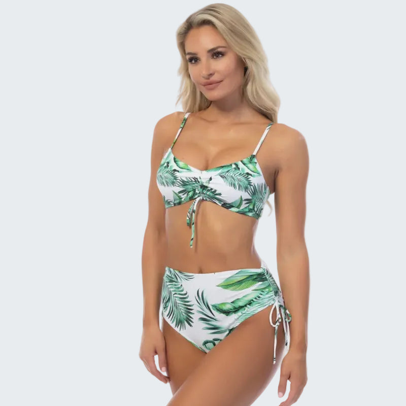 Woman wearing a tropical leaf patterned bikini on a white background