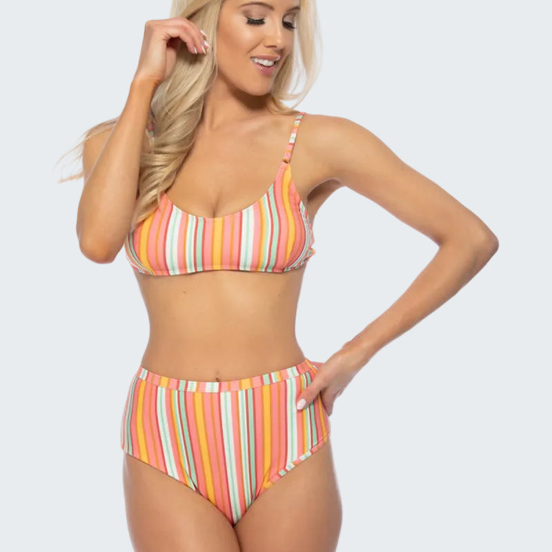 Woman wearing a colorful striped bikini on a white background