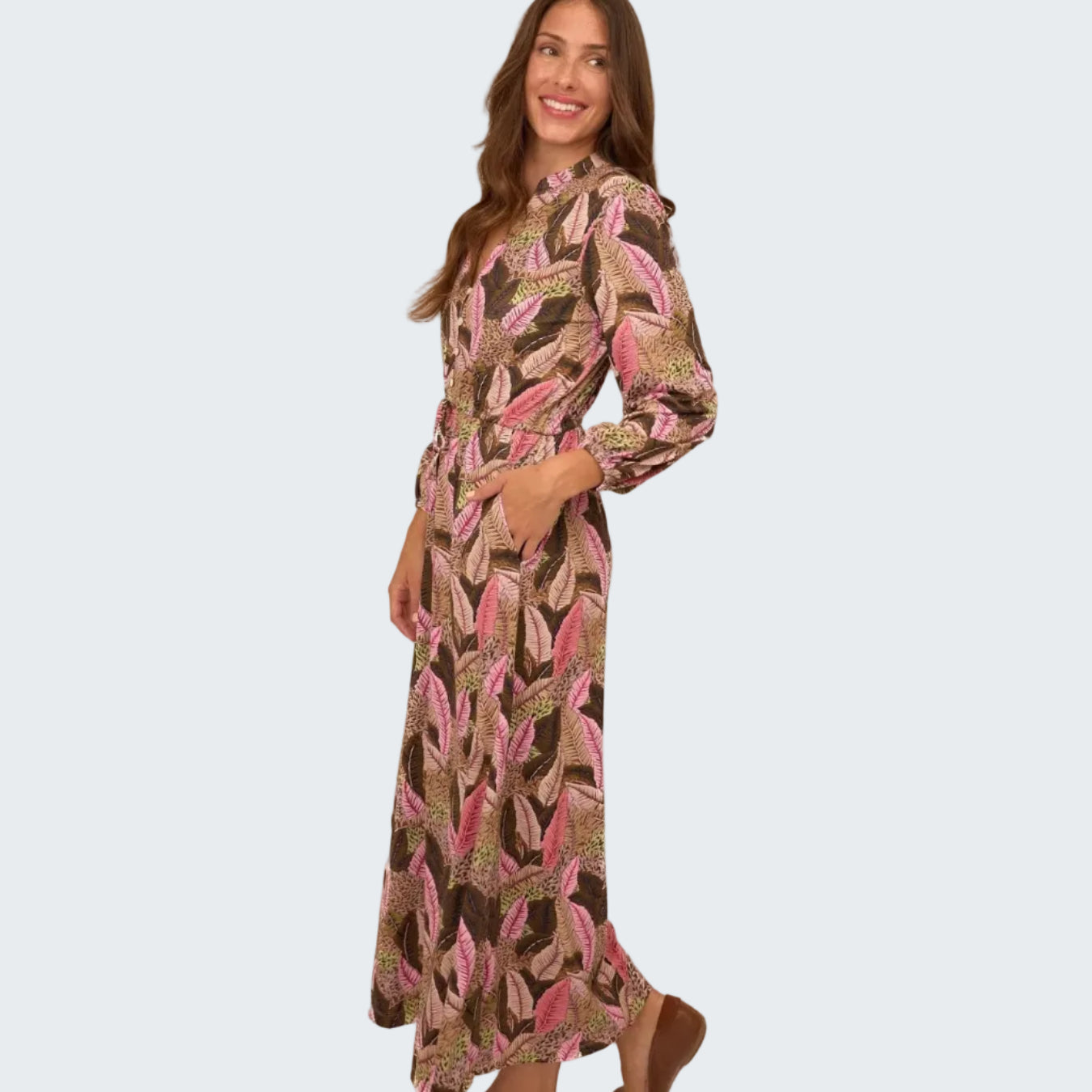 Woman wearing a long, patterned dress on a white background