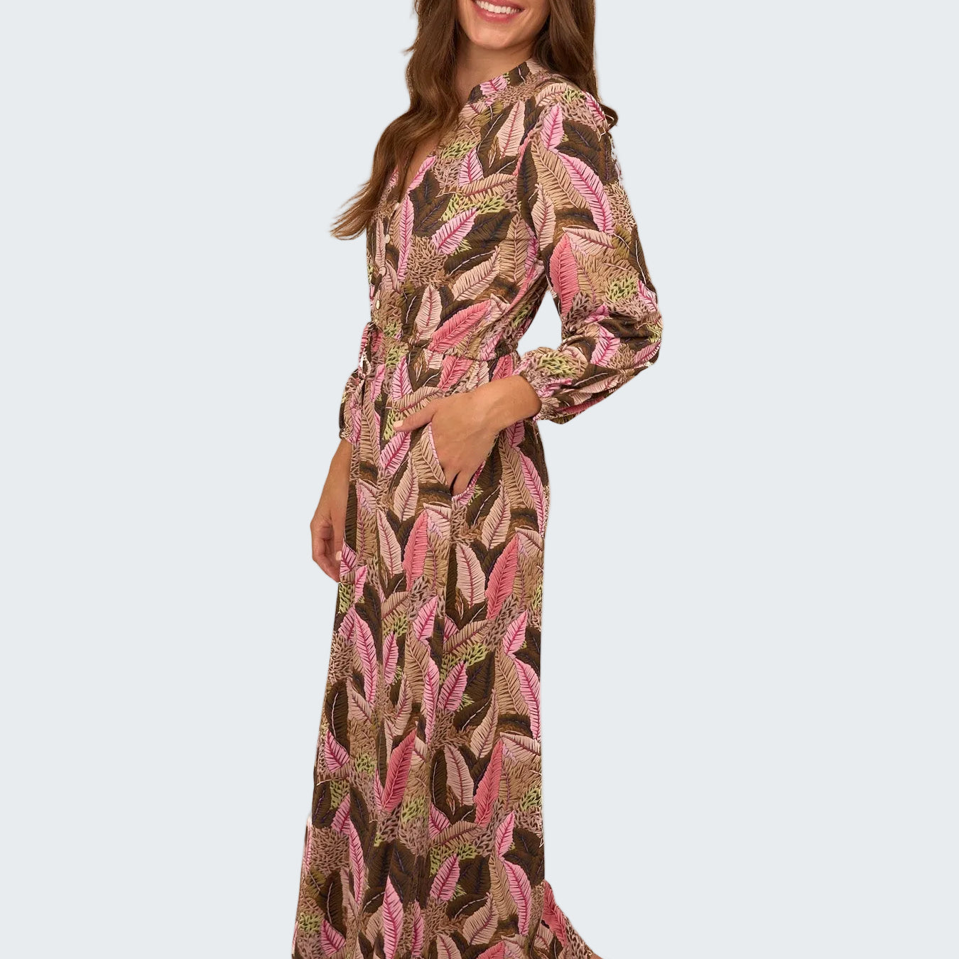 Woman wearing a long, patterned dress on a white background