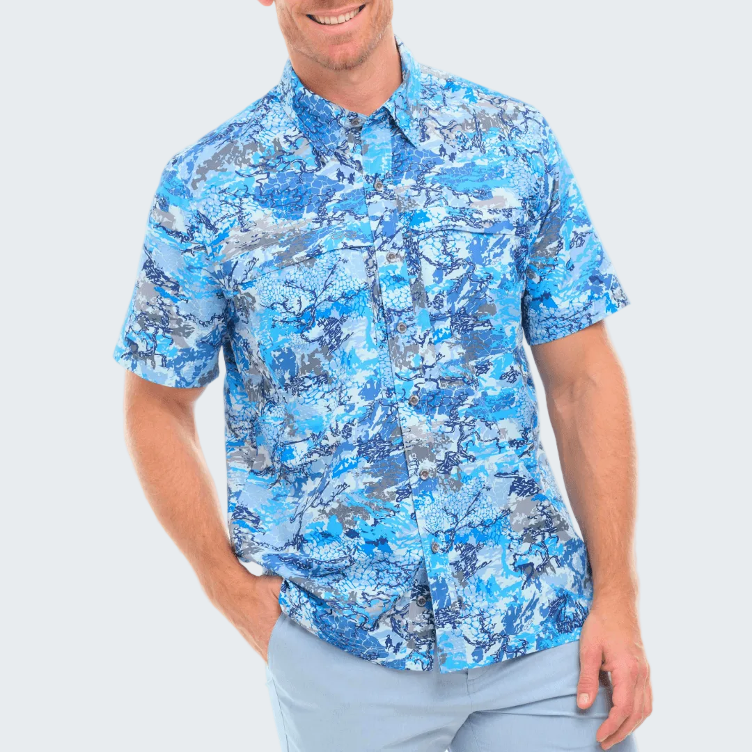 Man wearing a blue and gray patterned shirt on a white background