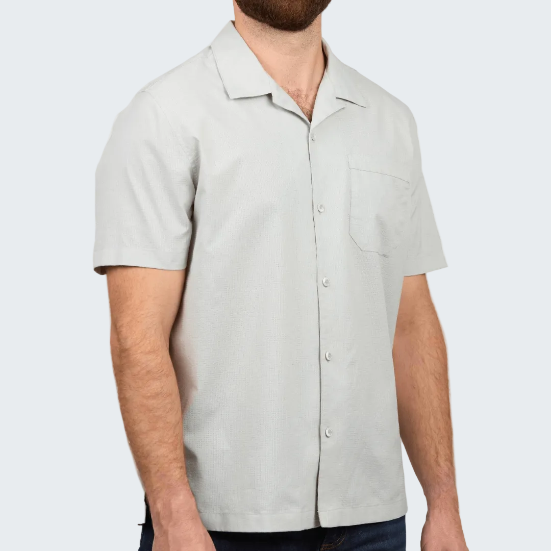 Man wearing a light gray short-sleeve shirt on a white background