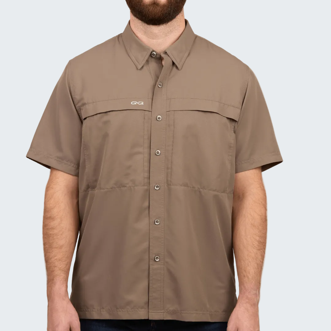 Man wearing a brown short-sleeve shirt with a brand logo on a white background