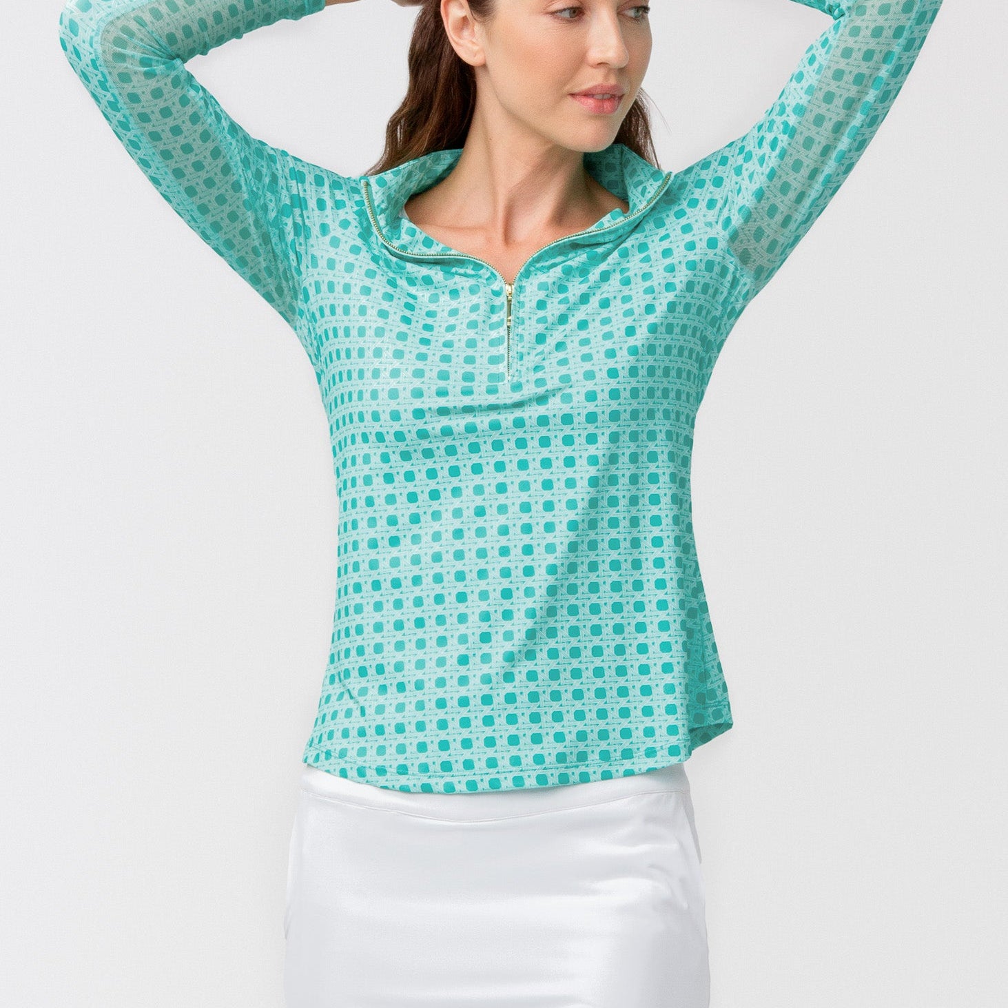 Woman wearing a teal checkered shirt and white skirt on a light gray background