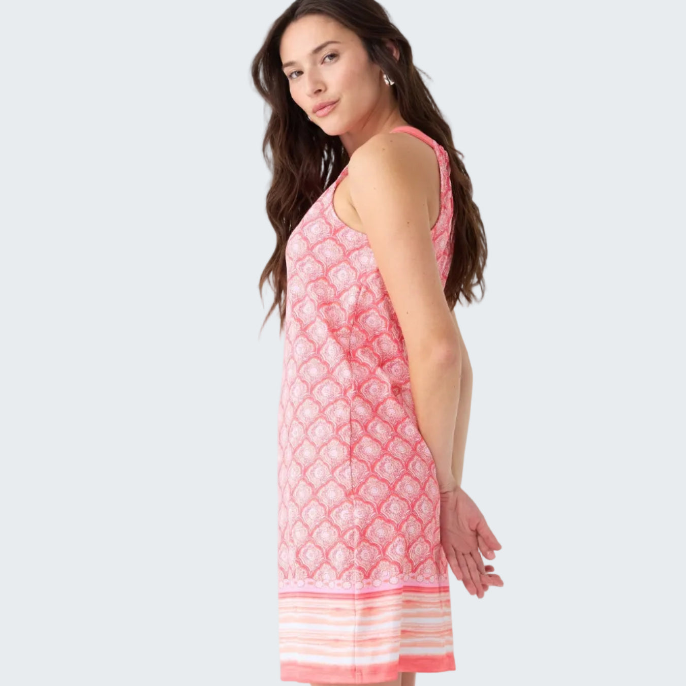 Woman wearing a pink patterned dress on a white background