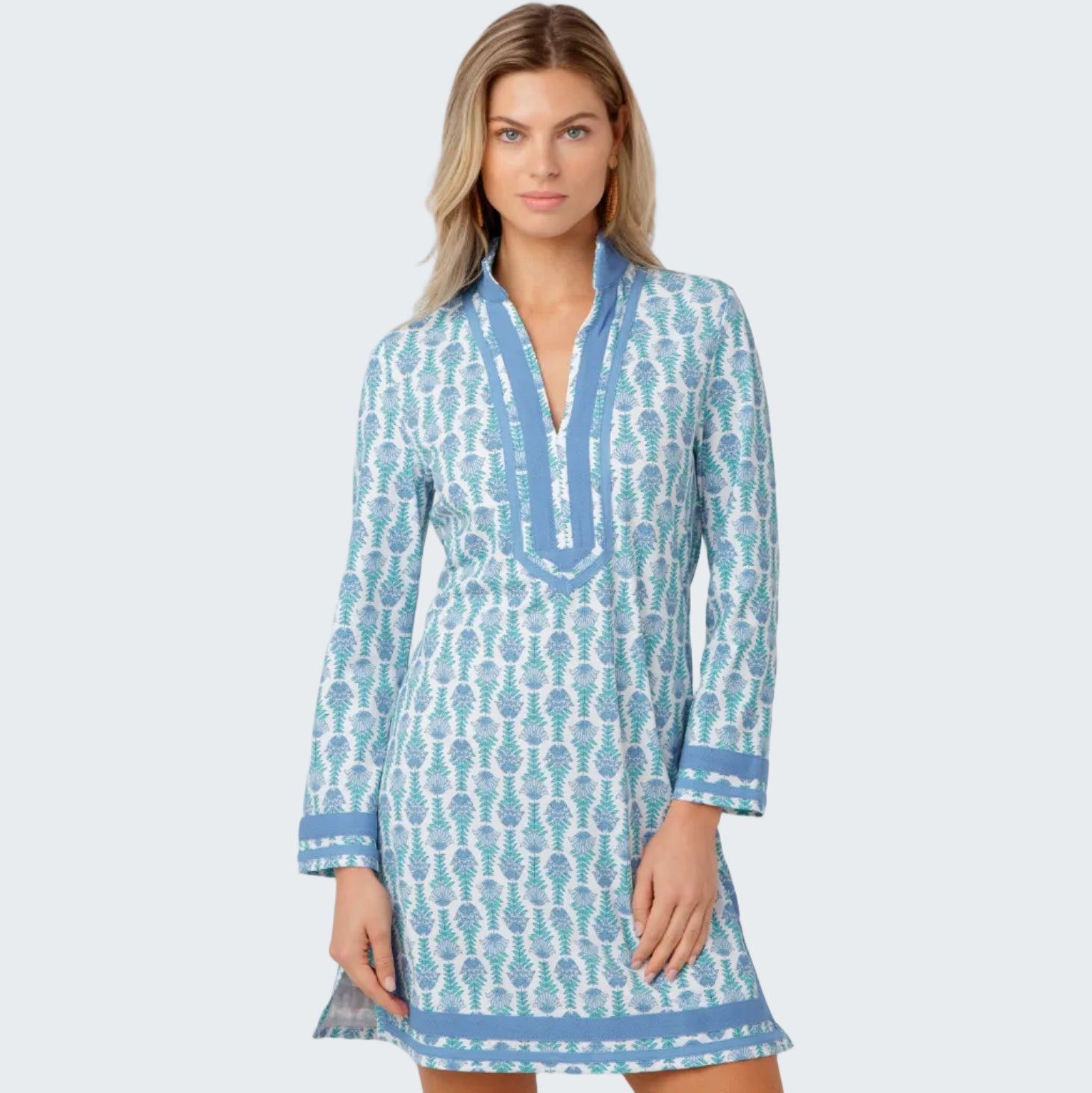 Woman wearing a blue and white patterned dress on a light gray background