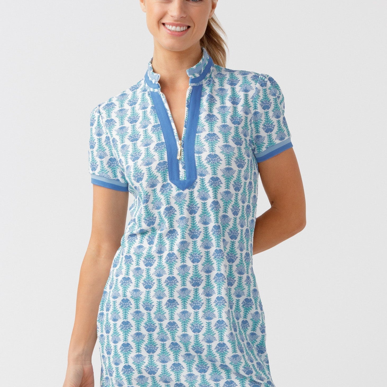 Woman wearing a blue and white patterned dress on a light gray background